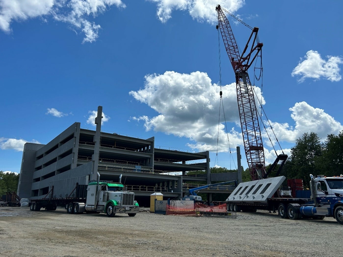 Ground view of a parking garage under construction. Crane and construction equipment at work.