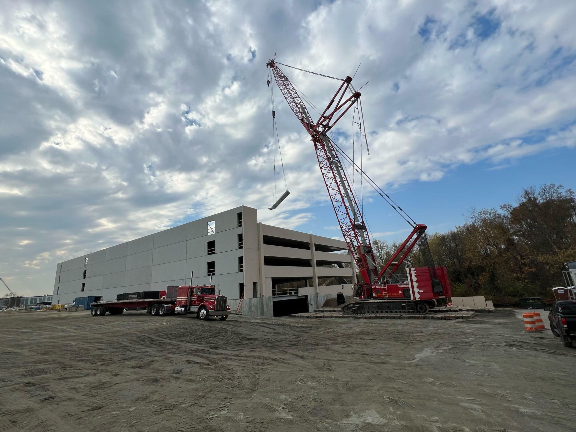 Crane at work on parking garage structure.