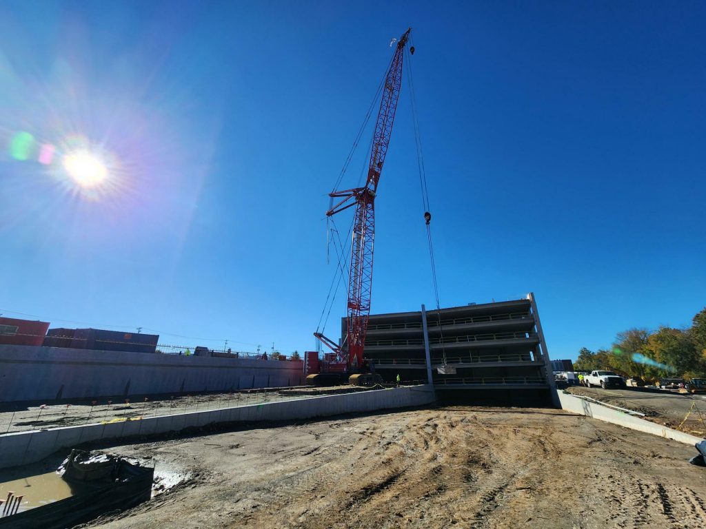 Crane at work on parking garage structure.