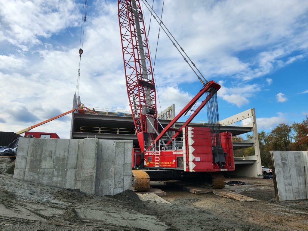 Crane at work on parking garage structure.